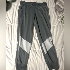 Nike joggers in the color grey with 2 white stripes at the bottom